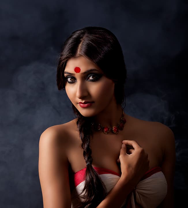 Red bindi and braided hair in smoke