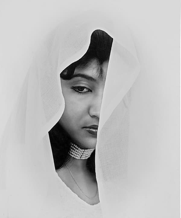 Face half-hidden by a white veil