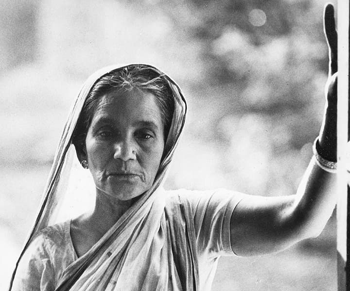 Elderly woman in sari at her doorway