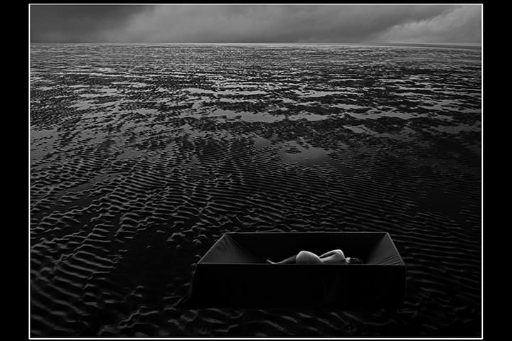 Figure curled in black box on tidal flats